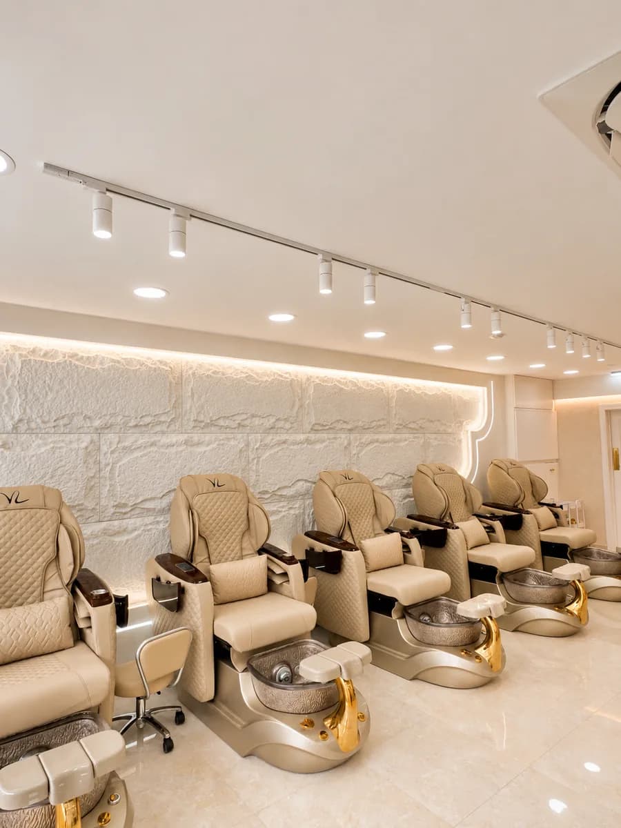 Pedicure spa chairs with gold-finished basins at Véra Nail Studio